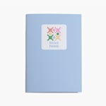 Carnet bleu clair avec un sticker du logo United School collé sur la couverture.