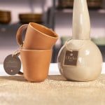 Une étiquette à fil attachée à une tasse et à un contenant en céramique avec une ficelle.