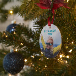 Une décoration originale sur un sapin de Noël avec la photo d’une petite fille portant des lunettes de soleil.