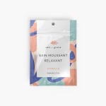 Photo d’une pochette tenant debout contenant des sels de bain parfumés au pamplemousse.