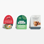 Des cartes postales ovales, en demi-cercle et en forme de feuille, toutes posées contre un mur et faisant la publicité de différents restaurants.