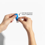 Une personne en train de changer le coussin encreur d’un petit tampon encreur rond, avec une note indiquant que le coussin est facile �à changer.