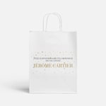 Un sac en papier blanc orné d’étoiles dorées, avec un texte célébrant un 60e anniversaire.