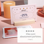 Une carte postale avec effet métallisé en relief, rangée dans un support en bois sur un comptoir de présentation.