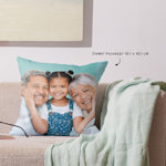 Un coussin personnalisé avec la photo de grands-parents et de leur petite-fille.