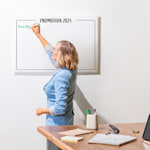 panneau rectangulaire en acrylique transparent avec le nom et le logo d’une entreprise sur un mur blanc en briques dans un bureau