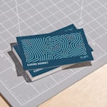 Une pile de cartes de visite personnelles au fini mat sur un tapis de découpe.