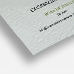 Primo piano su dei biglietti da visita in carta ruvida non patinata che ne mette in evidenza gli angoli squadrati e la particolare trama del materiale che ricorda quella della tela.