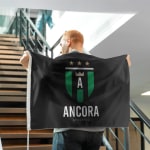 Un uomo tiene una bandiera raffigurante lo stemma di una squadra sportiva.