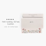 Forsiden og baksiden av en blomstrede konvolutt trykket med både mottakers og avsenders adresse, med kundeanmeldelse: «Helt nydelig. Topp kvalitet.»