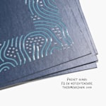 Nærbilde av visittkort med UV-spot finish med pregede bokstaver og en 3D-look som reflekterer lyset.