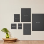 Bedrukte canvassen hangen aan de muur, met een label met de afmetingen erbij.
