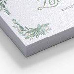 Close-up van een stapel parelmoer visitekaartjes met scherpe rechte hoeken en een glanseffect.