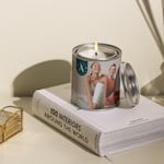 Een bedrukte kaars gepersonaliseerd voor een yogastudio met een bedrijfslogo en een foto van een vrouw in yogakleding.