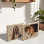 Twee houten fotoblokken op een tafelblad. Op het ene een foto van een moeder met haar baby en op het andere een foto van een hond en een kat.