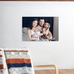 Uma impressão em acrílico que mostra uma fotografia de uma família, com dois pais, um bebé e um cão.