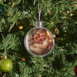 Uma bola de Natal pendurada numa árvore de Natal, personalizada com a imagem de uma mãe e do seu filho a abraçarem-se.