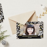 Une enveloppe en papier kraft et une carte de vœux personnalisée avec la photo d’une petite fille.