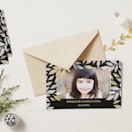 Um envelope de papel kraft e um cartão de boas festas personalizado com a fotografia de uma menina.