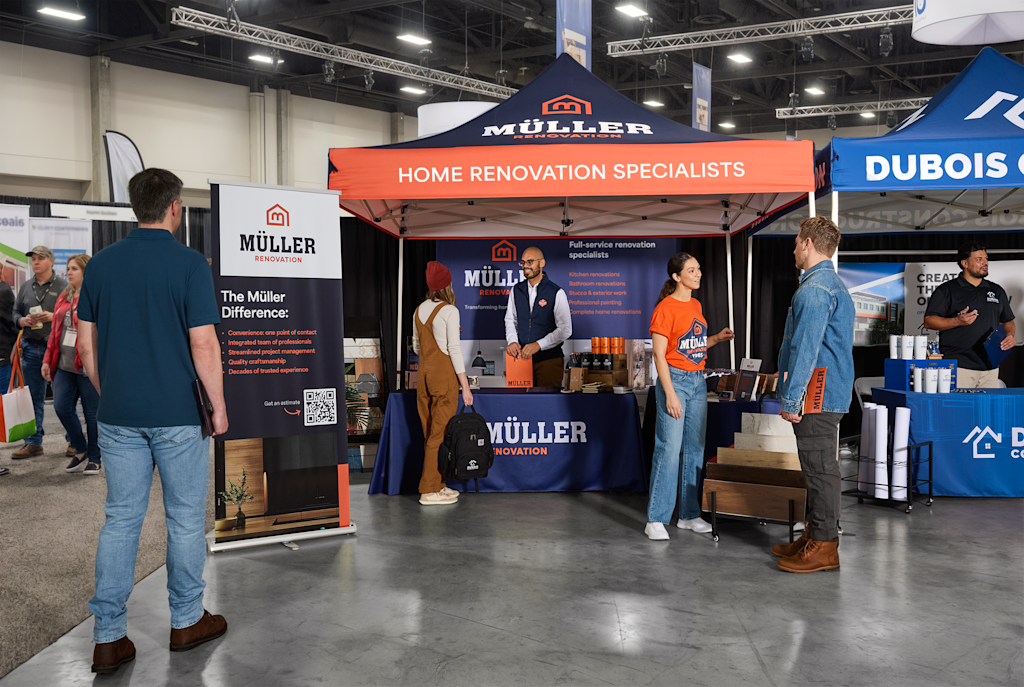 A trade show booth with a branded canopy tent, roller banner, and staff members engaging with visitors at an indoor exhibition.
